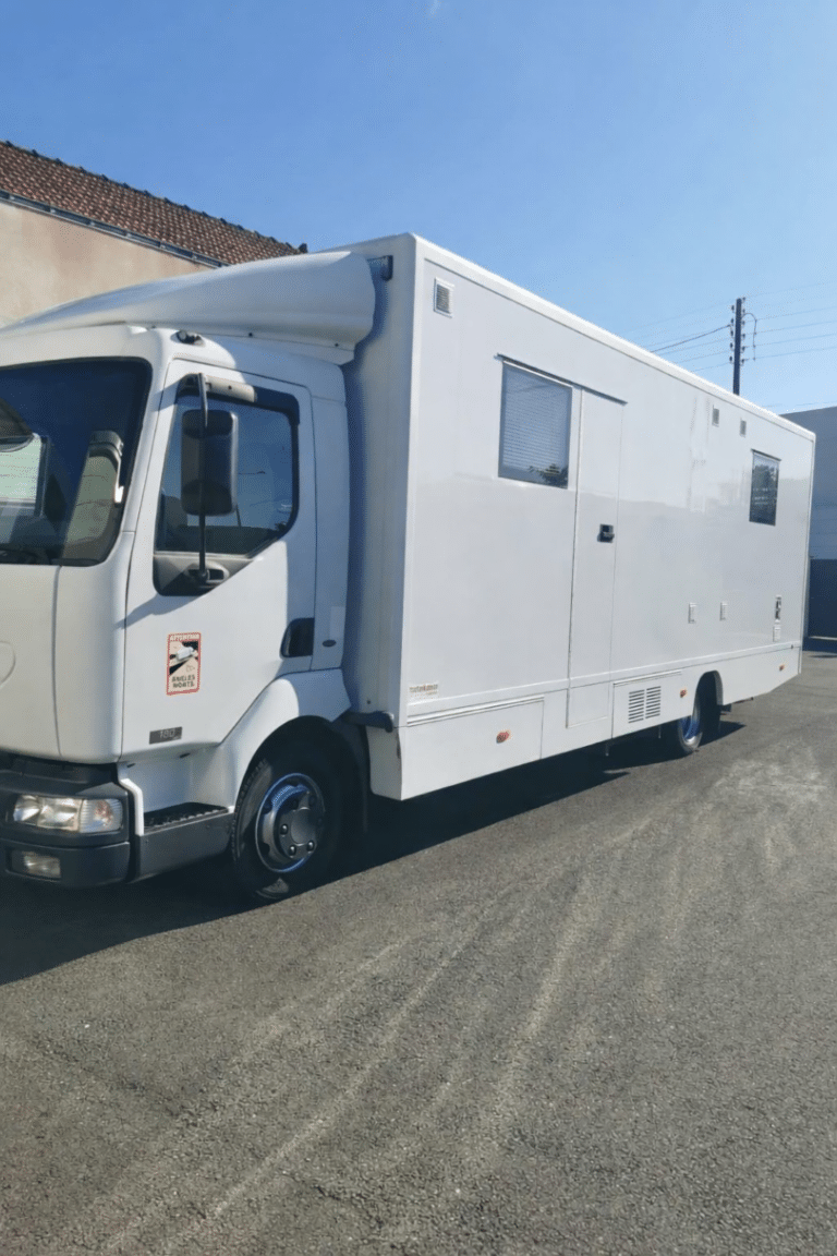 Camion blanc aménagé stationné en plein soleil