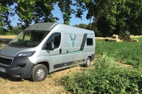 Fourgon gris garé près de bottes de foin