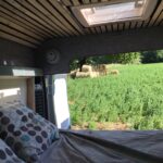 Intérieur de van avec vue sur champs verdoyants.