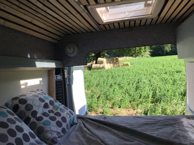 Intérieur de van avec vue sur champs verdoyants.