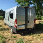 Camping-car stationné dans un champ verdoyant.