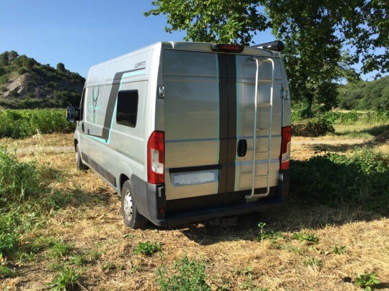 Camping-car stationné dans un champ verdoyant.