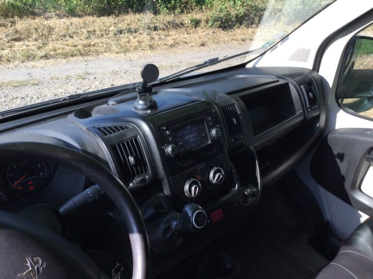 Intérieur de van Peugeot avec tableau de bord ensoleillé.