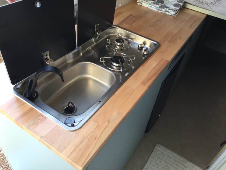 Cuisine compacte avec évier et plaque de cuisson.
