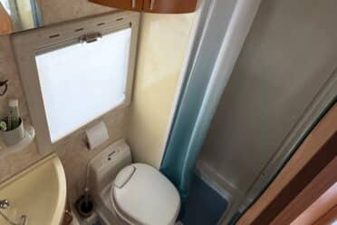 Kleines Badezimmer mit Toilette und Dusche.