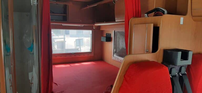 Intérieur d'une caravane aménagée avec fenêtres et rideaux.