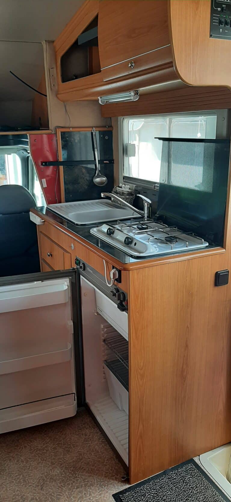 Cuisine de caravane avec frigo et évier.