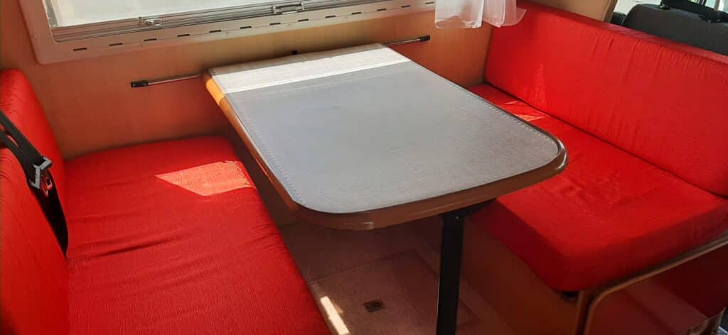 Coin repas camping-car avec banquettes rouges
