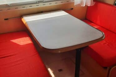 Coin repas camping-car avec banquettes rouges