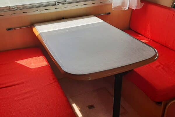 Coin repas camping-car avec banquettes rouges