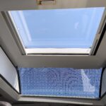 Toit ouvrant avec ciel dégagé visible.