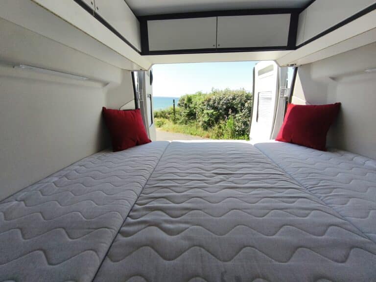 Intérieur de van aménagé avec vue sur mer.