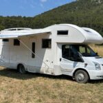 Camping-car blanc stationné en plein air