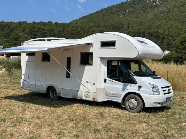 Camping-car blanc stationné en plein air