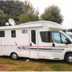 Camping-car blanc stationné dans un parc.