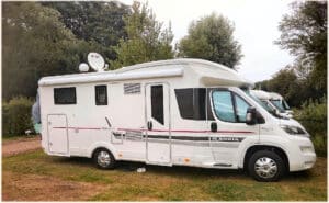 Camping-car blanc stationné dans un parc.