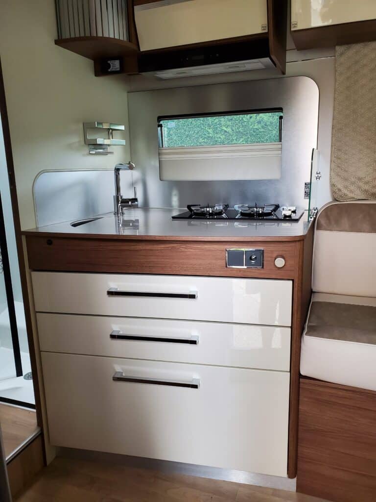 Cuisine compacte en bois et métal dans un camping-car.