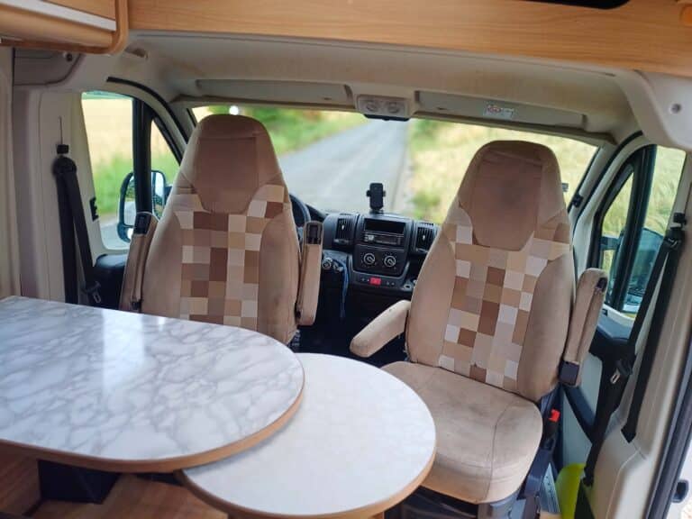Intérieur d'un camping-car moderne avec sièges et table.