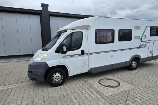 Wohnmobil vor einem Industriegebäude geparkt.