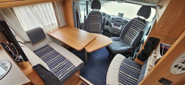 Intérieur confortable de camping-car avec sièges et table.