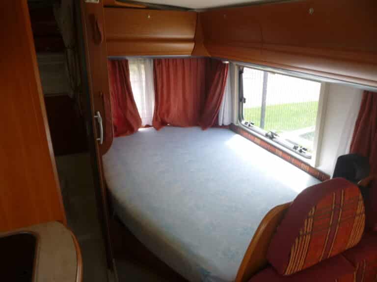 Lit dans un camping-car avec rideaux rouges fermés