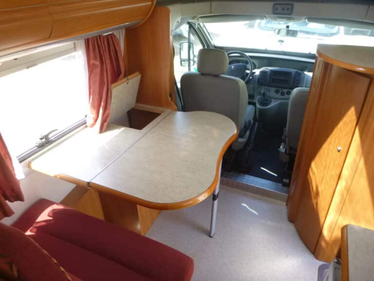 Intérieur d'un camping-car avec table et sièges.