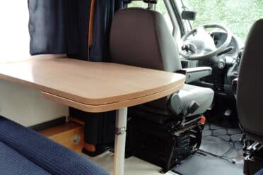 Intérieur d'un camping-car avec table et sièges.
