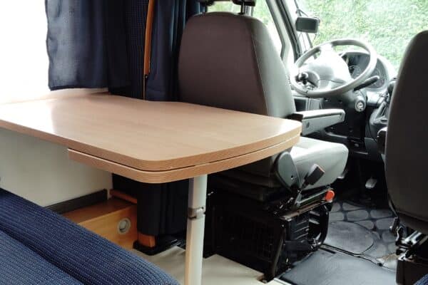 Intérieur d'un camping-car avec table et sièges.