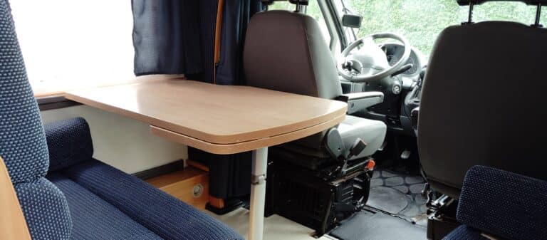 Intérieur d'un camping-car avec table et sièges.