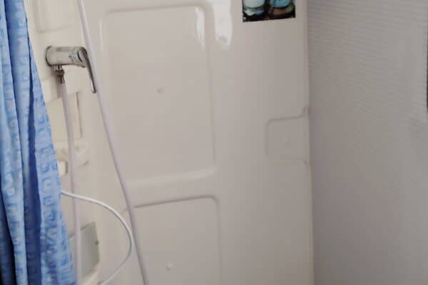 Salle de bain compacte avec douche et WC.