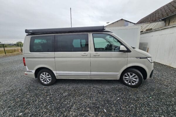 Van beige stationné sur un parking extérieur