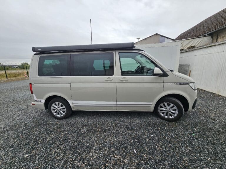 Van beige stationné sur un parking extérieur