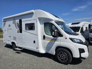 Camping-car blanc stationné sur une aire.