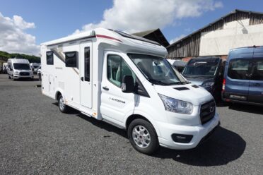 Camping-car blanc stationné sur un parking.