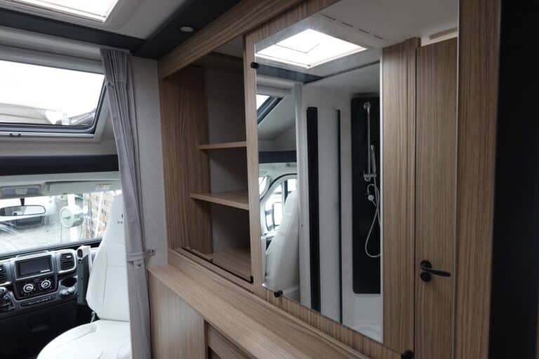 Intérieur d'un camping-car avec douche et siège conducteur.