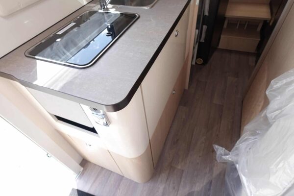 Cuisine intégrée moderne avec évier et plancher en bois.