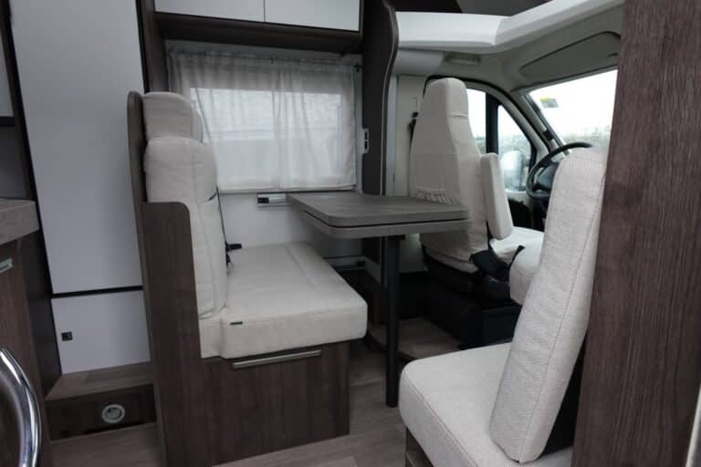 Intérieur de camping-car avec sièges et table.