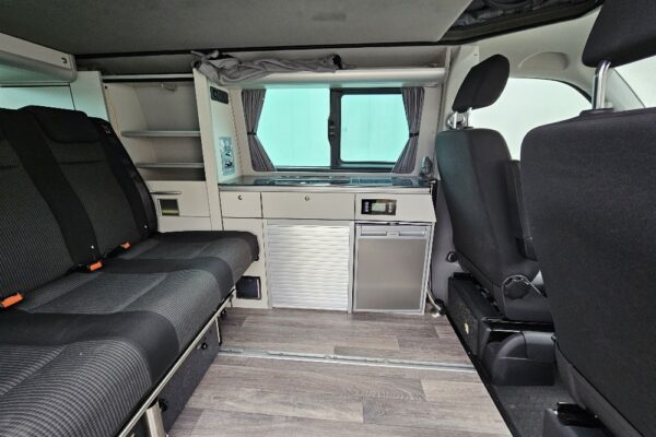 Innenansicht eines Campervan mit Küche.