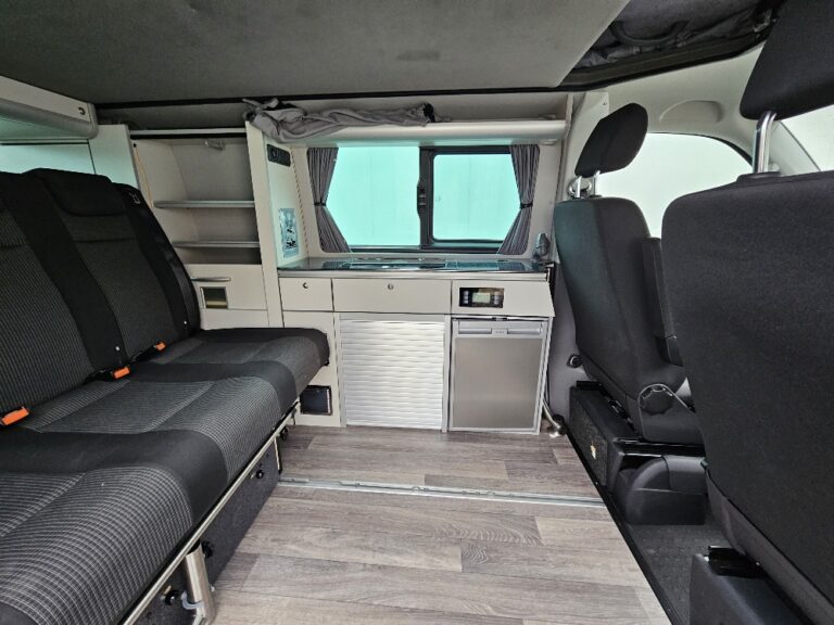 Intérieur d'un van aménagé avec cuisine.