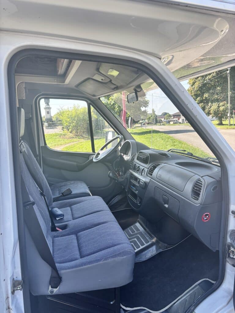 Intérieur d'un camion blanc garé sur route.