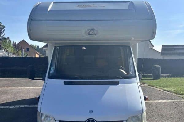 Camping-car Mercedes stationné sur un parking.