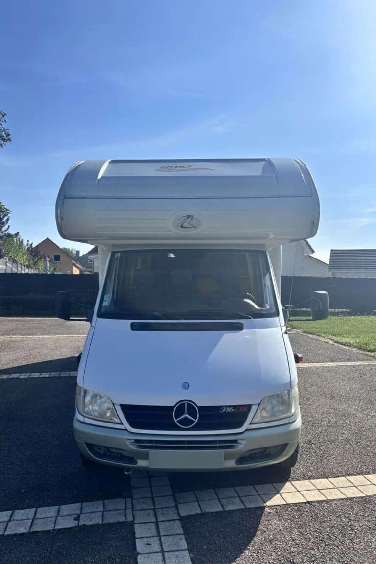 Camping-car Mercedes stationné sur un parking.