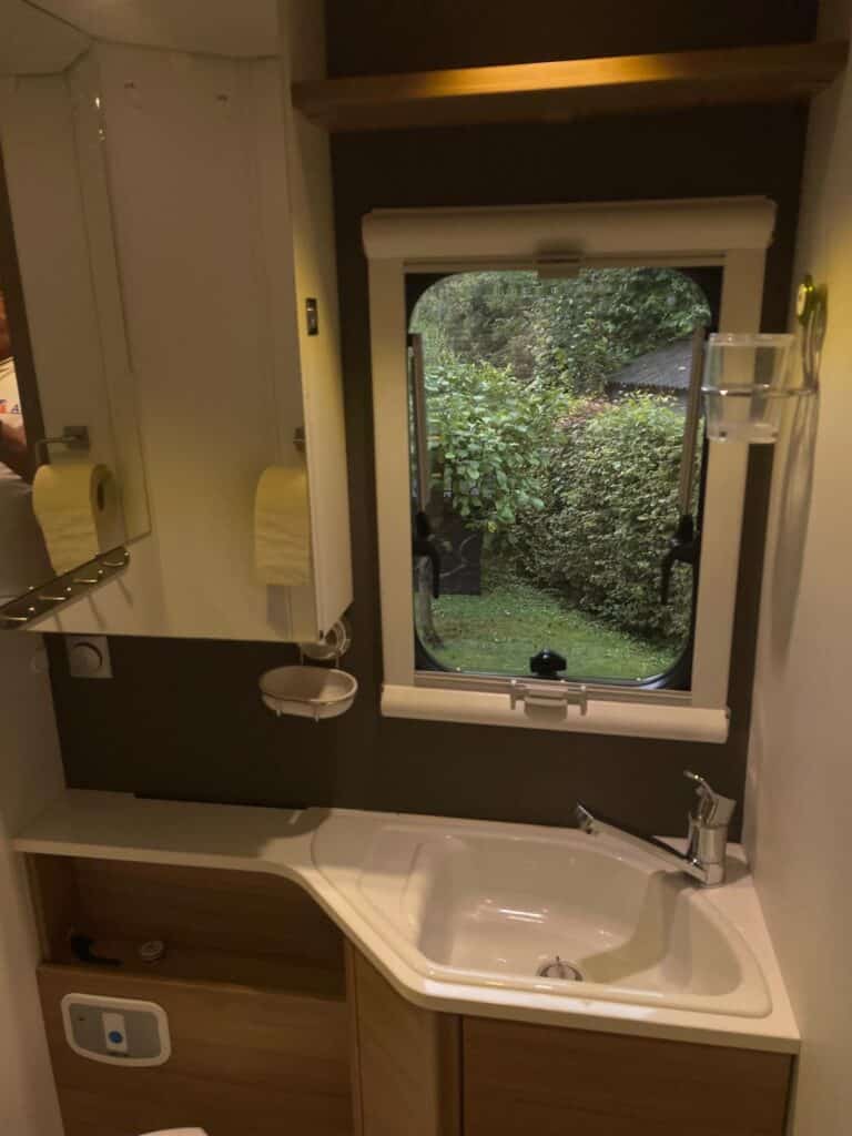 Salle de bain avec lavabo et fenêtre extérieure