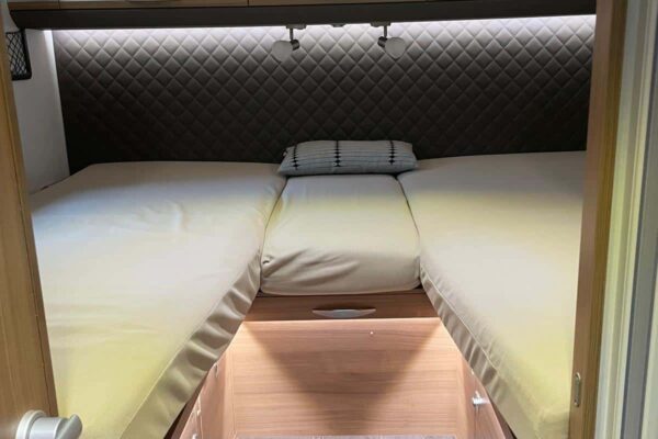 Bequemes Bett in einem modern eingerichteten Wohnwagen.