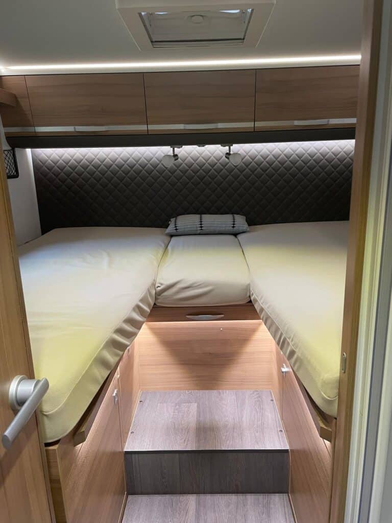 Lit confortable dans une caravane moderne aménagée.