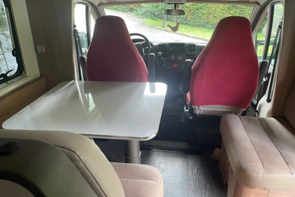 Geräumiger Innenraum von Wohnmobil mit Tisch.