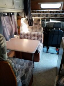 Intérieur de camping-car avec table et sièges rembourrés.