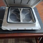 Ventilateur de toit ouvert sur table en bois.