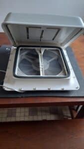 Ventilateur de toit ouvert sur table en bois.
