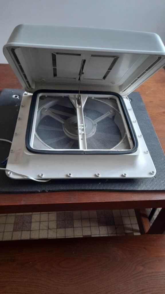 Ventilateur de toit ouvert sur table en bois.